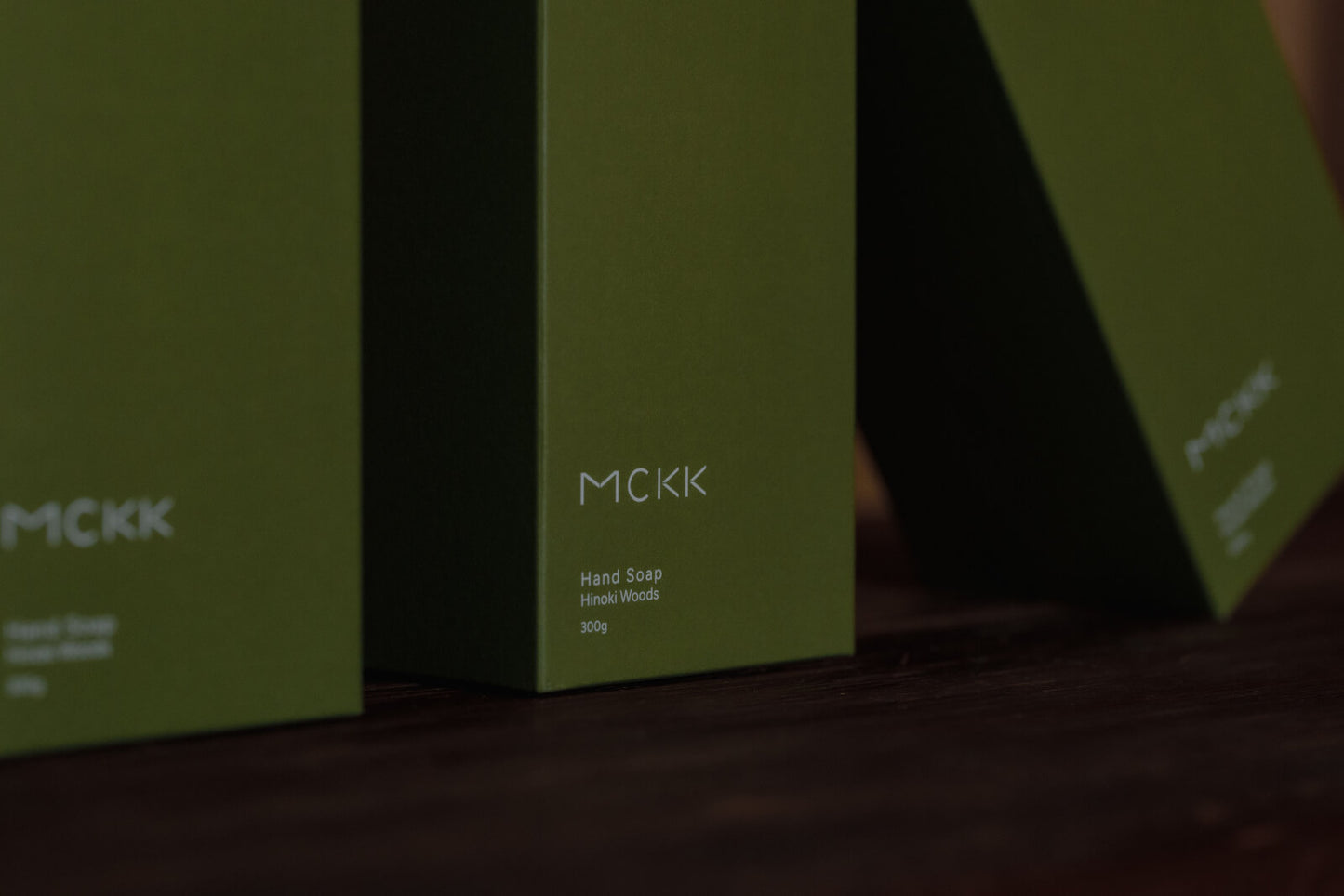 MCKKのハンドウォッシュが箱に入った状態で3本並ぶ、斜め横からの構図。檜の香り・天然由来96.9%